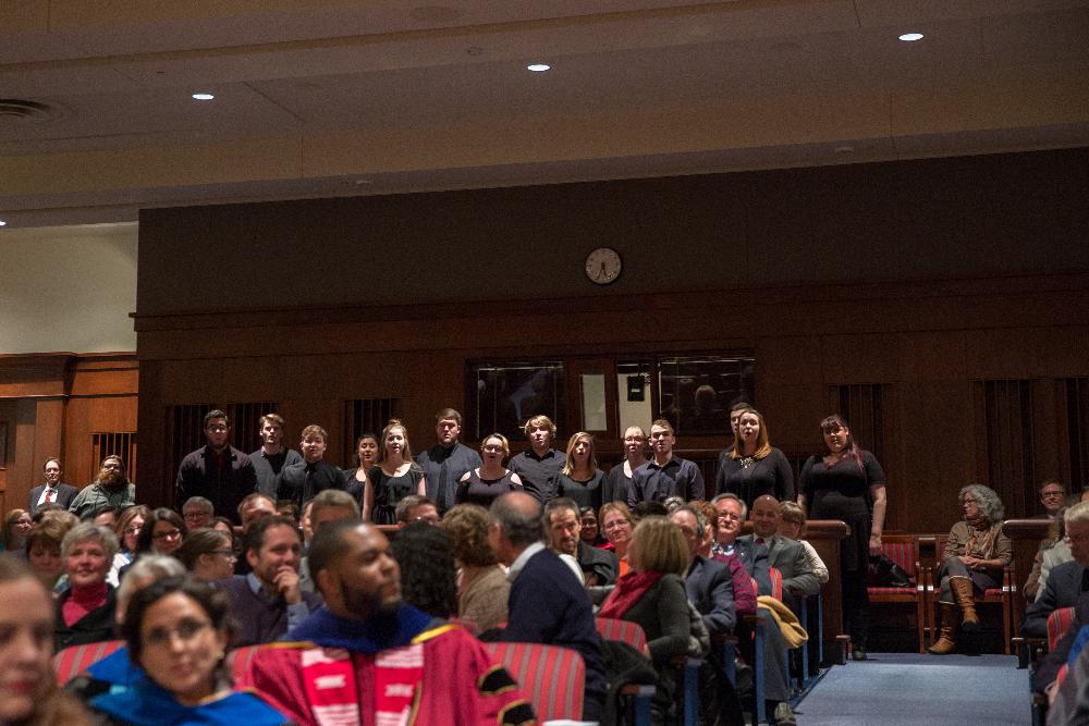 A student choir stands in the audience
